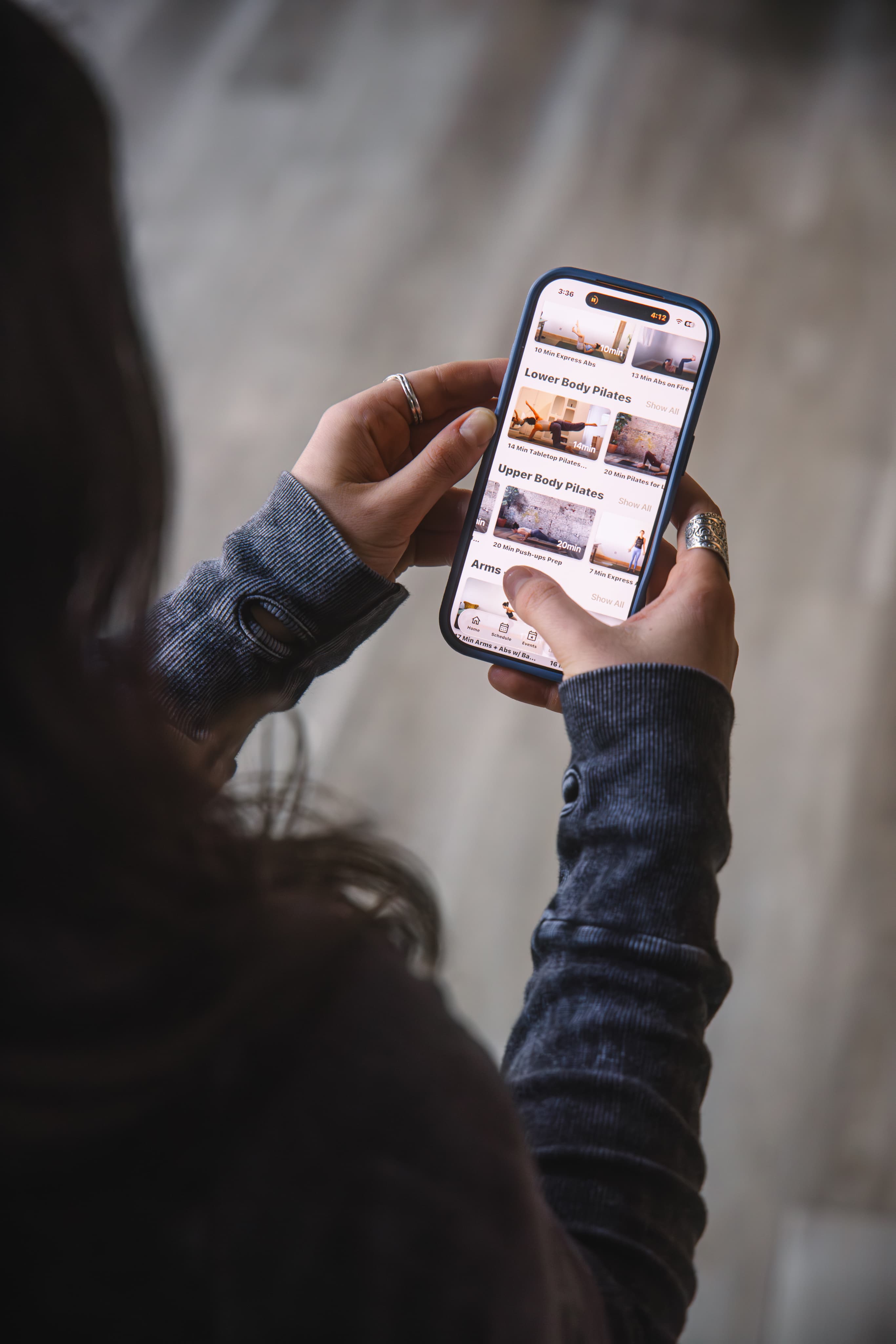 Woman holding an iPhone with Arketa's mobile app