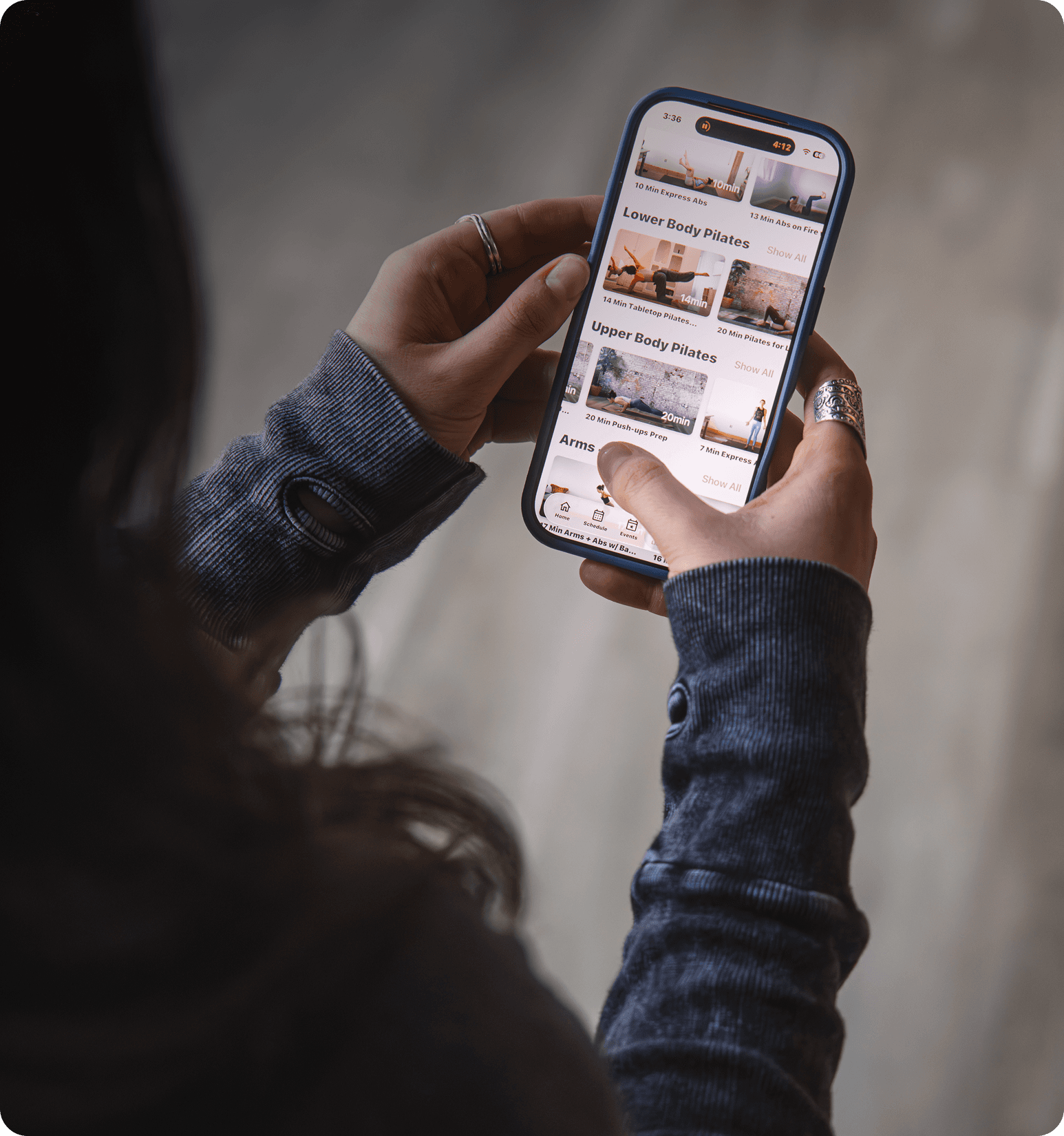 Woman holding her phone with the Arketa app